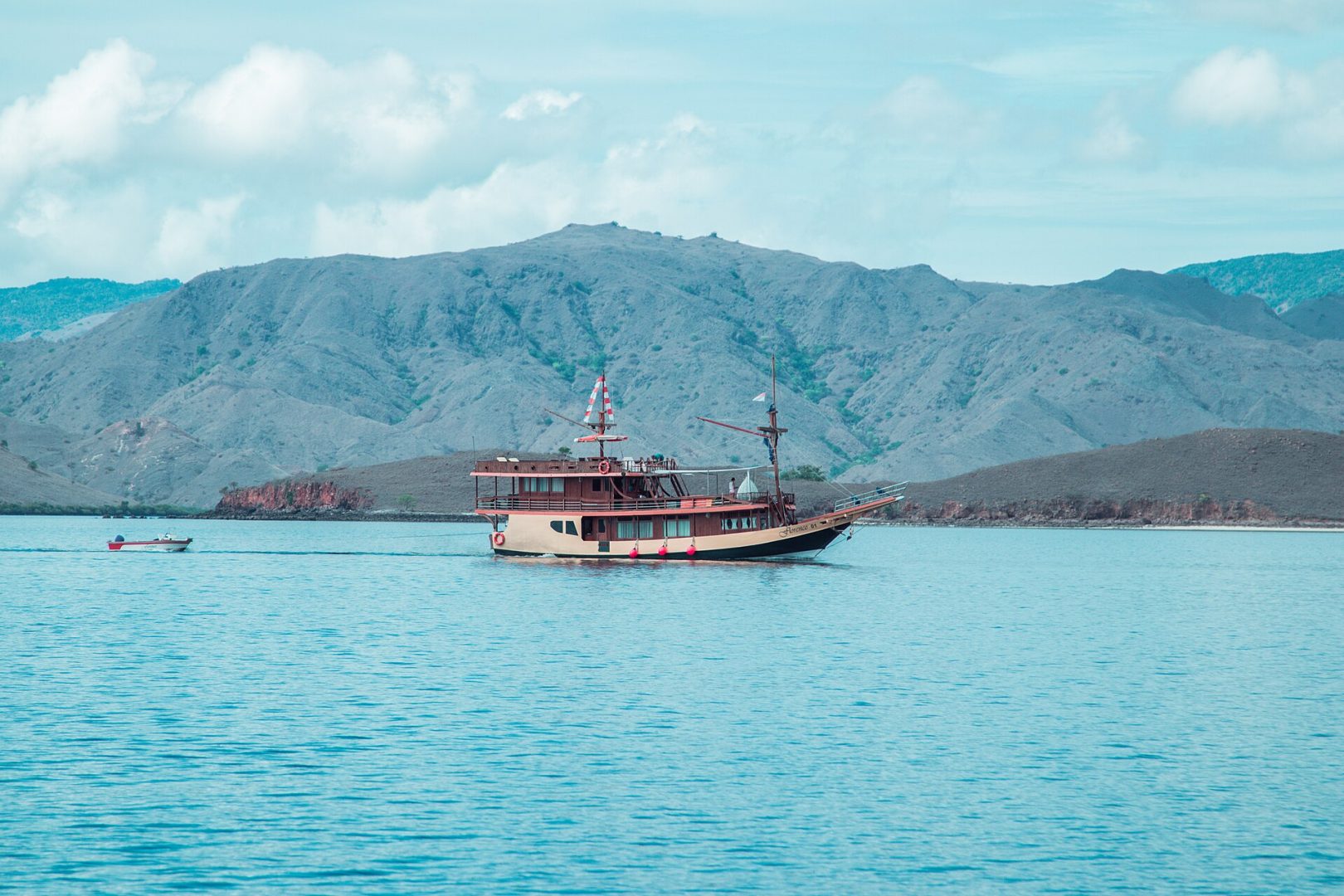 Traditional wooden phinisi sailing boat anchored in the bay of Labuan Bajo, Flores