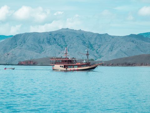 Traditional wooden phinisi sailing boat anchored in the bay of Labuan Bajo, Flores